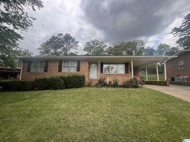 ranch-style house featuring a front yard, brick siding, a carport, and driveway