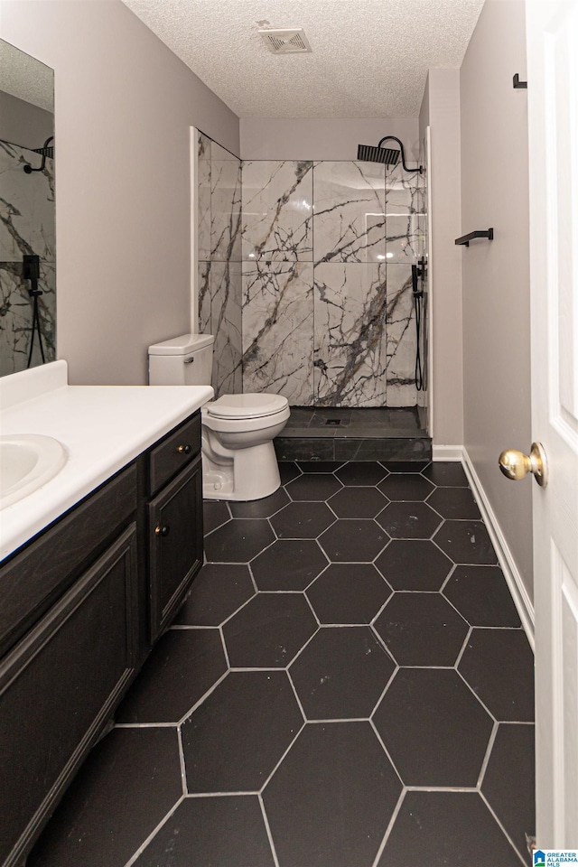 bathroom featuring a textured ceiling, visible vents, vanity, toilet, and a marble finish shower