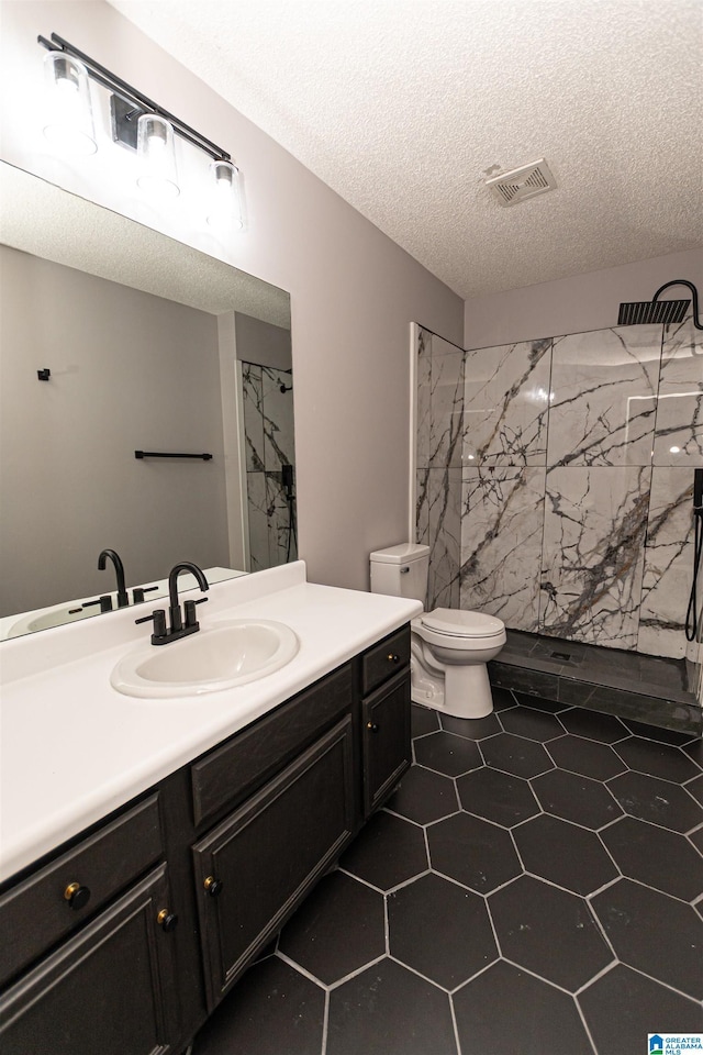 bathroom featuring visible vents, vanity, toilet, a textured ceiling, and a marble finish shower