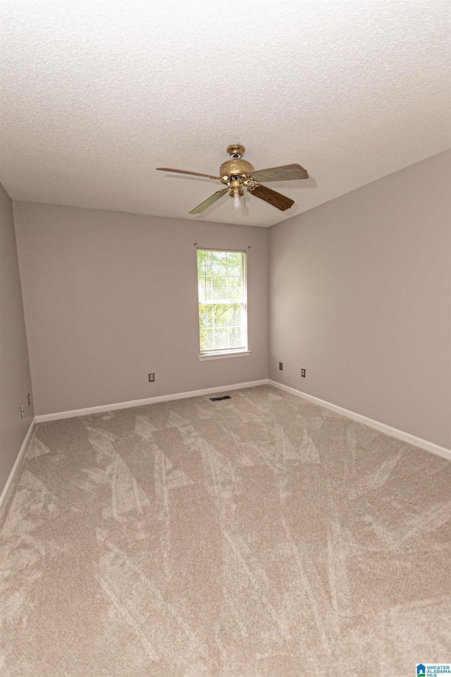 empty room featuring a ceiling fan, carpet flooring, and a textured ceiling