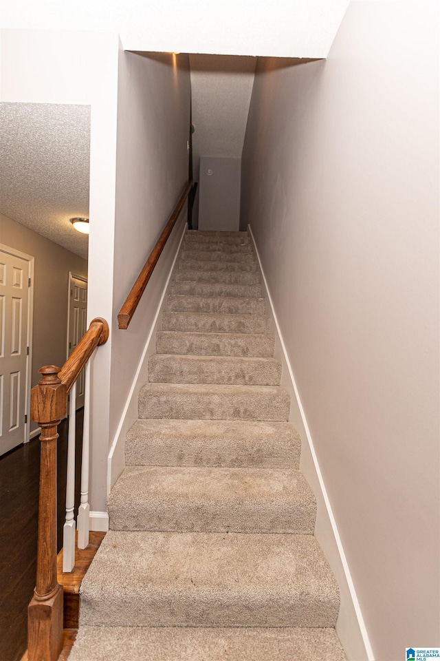 stairway with baseboards and wood finished floors