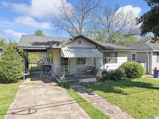 2110 S 4th Ave, Irondale, AL 35210 - view of front of house with a front yard, metal roof, concrete driveway, an attached carport, and a standing seam roof