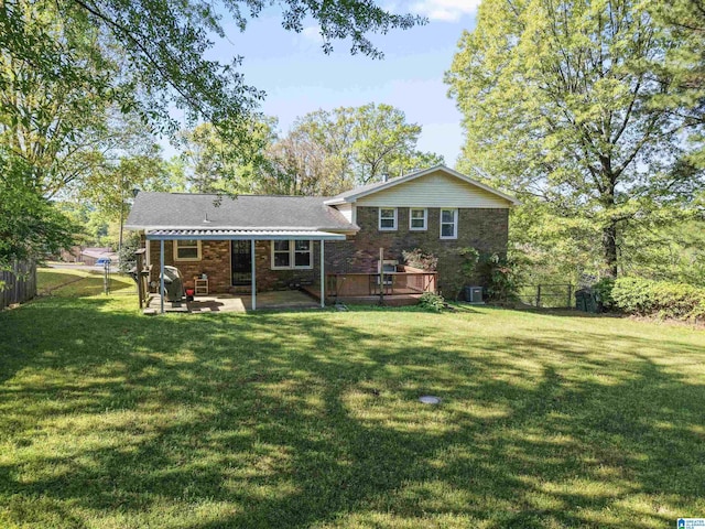 rear view of property with a wooden deck, a yard, a patio area, and fence