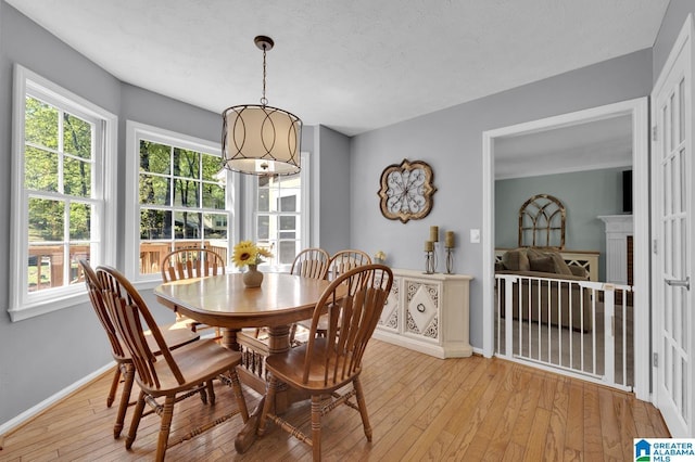 913 Falling Star Ln, Alabaster, AL 35007 - dining room featuring a fireplace, baseboards, and light wood-type flooring