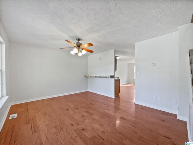 3 Holt Ave, Birmingham, AL 35214 - unfurnished living room featuring a textured ceiling, wood finished floors, a ceiling fan, and visible vents