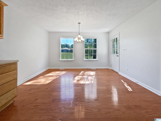 3 Holt Ave, Birmingham, AL 35214 - unfurnished dining area with a chandelier, a textured ceiling, wood finished floors, and baseboards