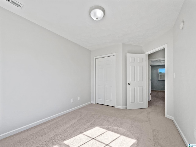 3 Holt Ave, Birmingham, AL 35214 - unfurnished bedroom featuring a closet, visible vents, light colored carpet, and baseboards