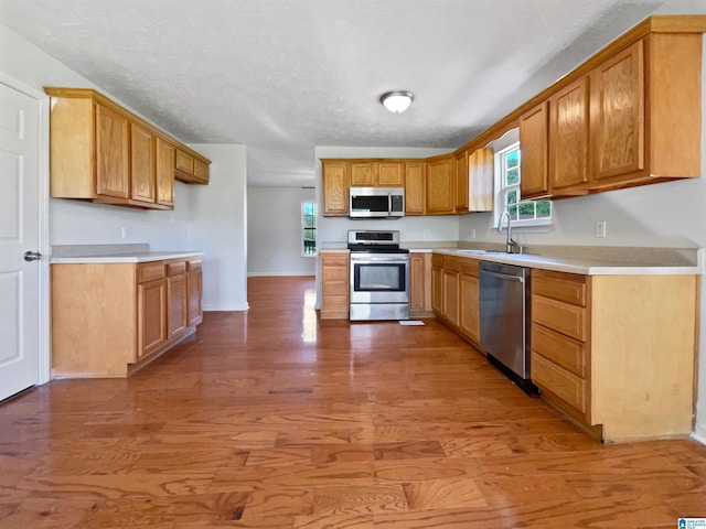 3 Holt Ave, Birmingham, AL 35214 - kitchen featuring light wood-type flooring, light countertops, a sink, stainless steel appliances, and baseboards