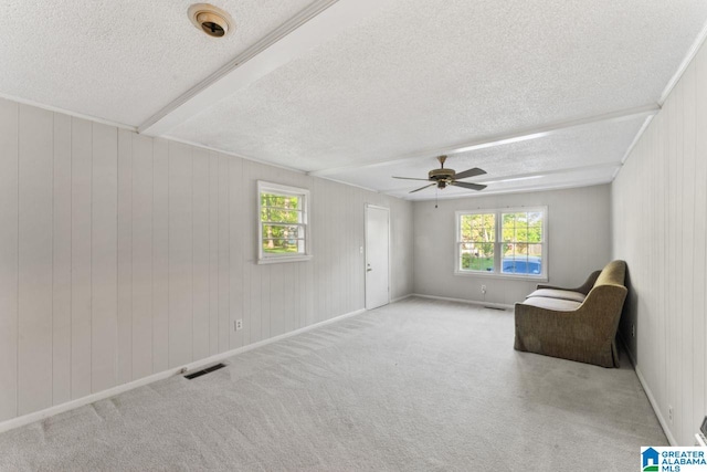 sitting room with a ceiling fan, a textured ceiling, visible vents, and carpet