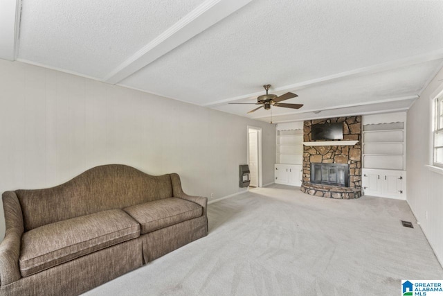 living area featuring carpet, a textured ceiling, a ceiling fan, and visible vents