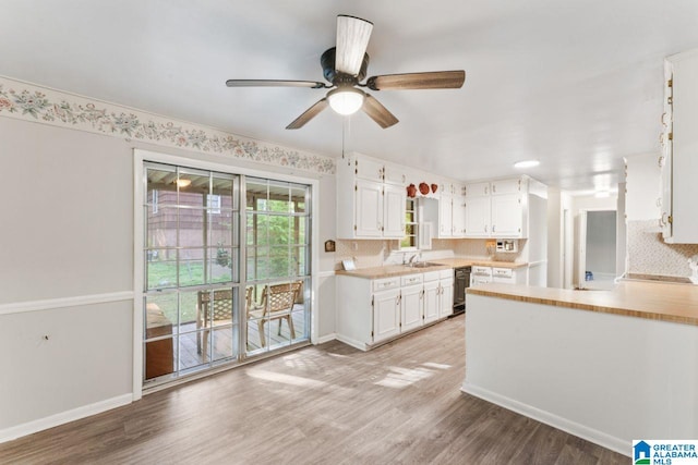 kitchen with white cabinets, a ceiling fan, light wood-style floors, and light countertops