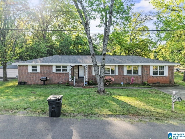 ranch-style house featuring brick siding, crawl space, and a front lawn