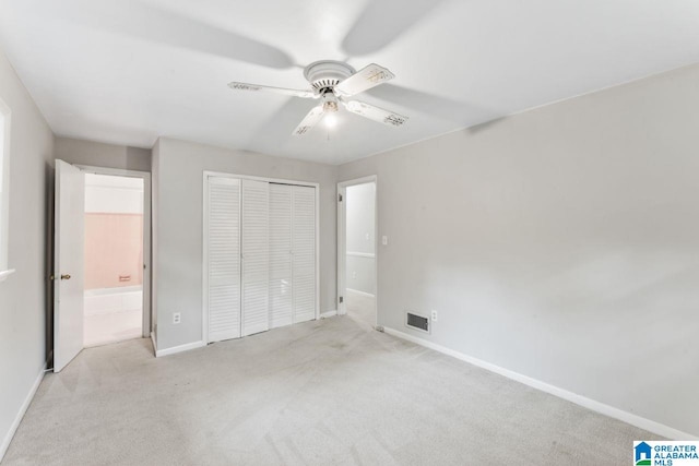 unfurnished bedroom featuring a closet, ceiling fan, carpet floors, baseboards, and visible vents