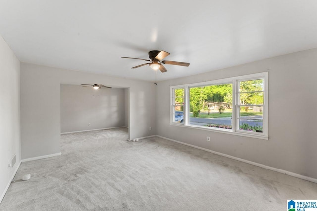 carpeted spare room with baseboards, a ceiling fan, and visible vents