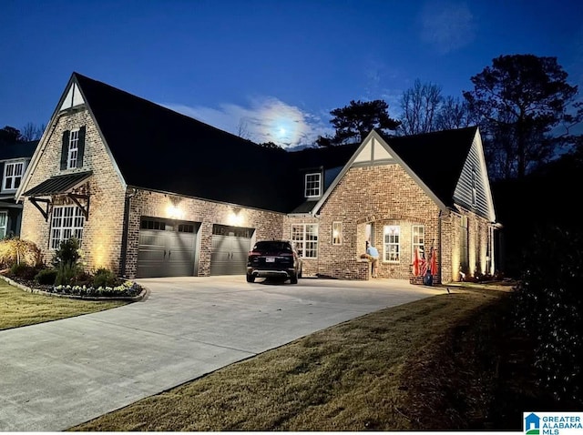 view of side of home with driveway and brick siding