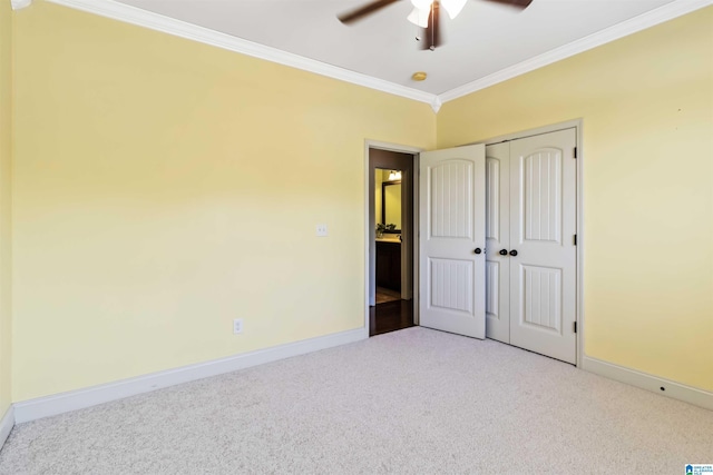 unfurnished bedroom with crown molding, baseboards, and carpet