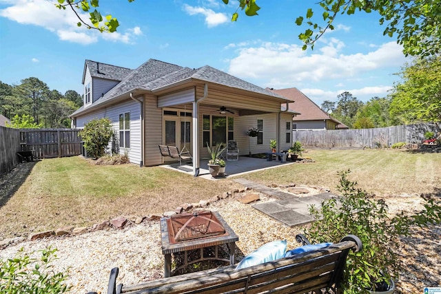 back of property featuring a patio, roof with shingles, a ceiling fan, a fenced backyard, and a yard