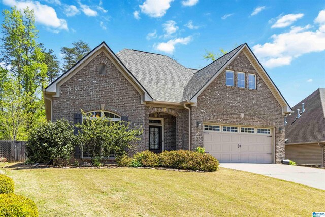 view of front of house with fence, brick siding, a front lawn, driveway, and roof with shingles