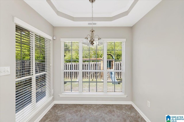 unfurnished dining area with a chandelier, visible vents, a tray ceiling, and baseboards