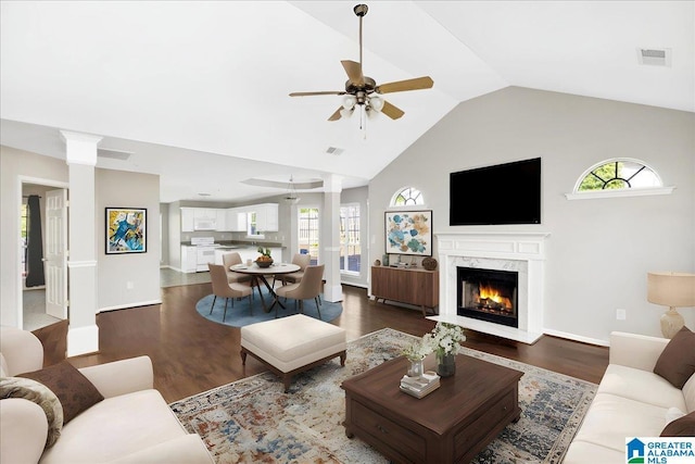 living area featuring dark wood-style floors, visible vents, decorative columns, and ceiling fan