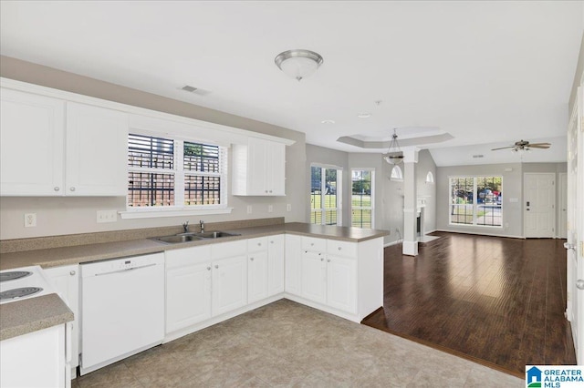 kitchen with open floor plan, a peninsula, visible vents, dishwasher, and a sink