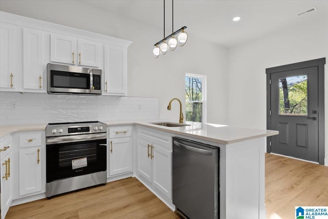 400 Ingram Ave W, Oneonta, AL 35121 - kitchen with a peninsula, backsplash, visible vents, appliances with stainless steel finishes, and a sink