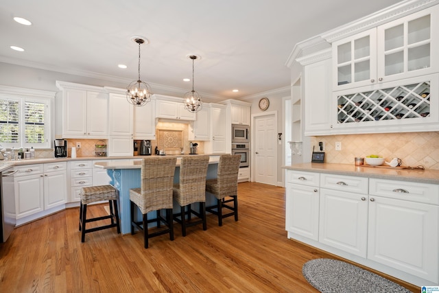 kitchen featuring a kitchen bar, light wood-type flooring, appliances with stainless steel finishes, and crown molding