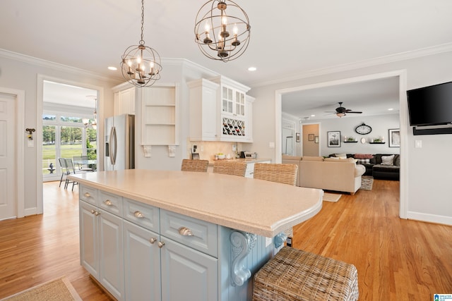 kitchen with ornamental molding, stainless steel fridge with ice dispenser, white cabinetry, and recessed lighting