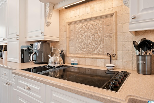 kitchen with black electric cooktop, light countertops, and tasteful backsplash