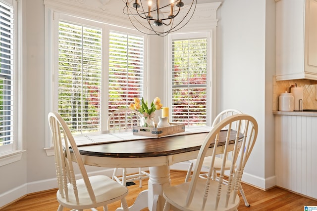 dining area featuring baseboards, an inviting chandelier, radiator, and light wood-style flooring