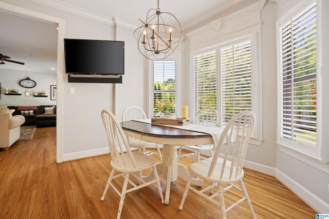 dining room with light wood-type flooring, baseboards, and ornamental molding
