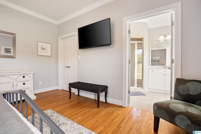bedroom featuring baseboards, crown molding, and light wood-type flooring