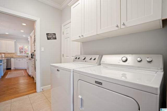 laundry area featuring recessed lighting, light tile patterned flooring, washing machine and clothes dryer, crown molding, and cabinet space