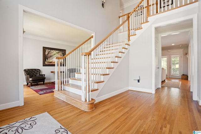 stairs featuring baseboards, wood finished floors, and crown molding