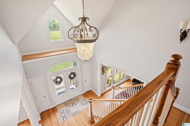 foyer entrance featuring high vaulted ceiling, a wealth of natural light, and wood finished floors