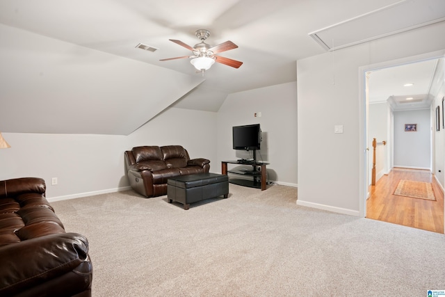 living room with attic access, a ceiling fan, visible vents, and light colored carpet