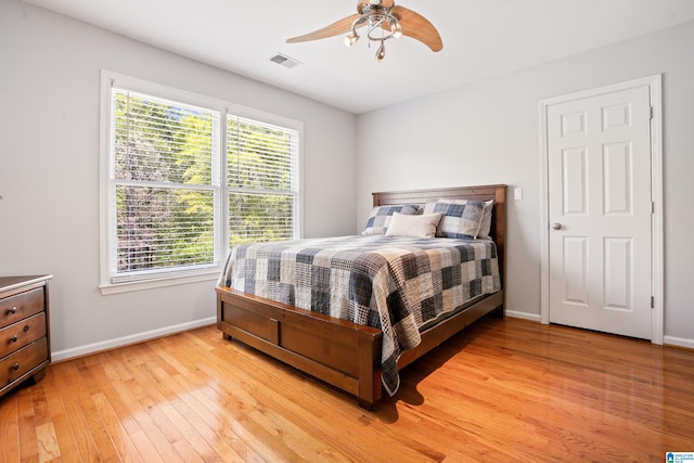 bedroom with visible vents, baseboards, light wood-style floors, and ceiling fan