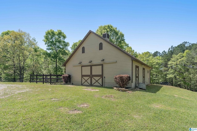 view of outbuilding featuring an outdoor structure and fence