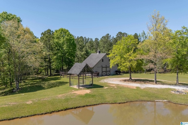 view of community with a gazebo, a lawn, and a water view