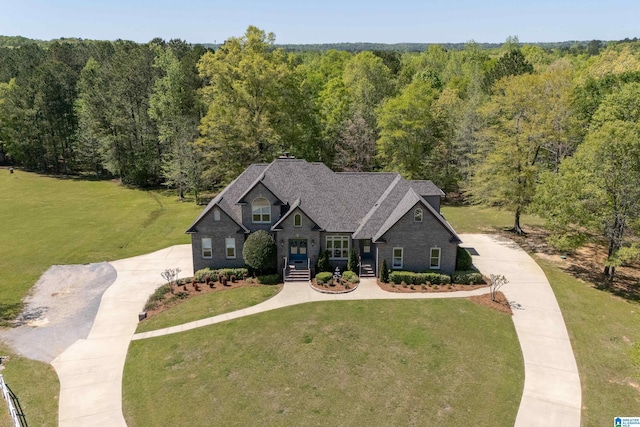 craftsman inspired home featuring a front lawn, driveway, and a view of trees