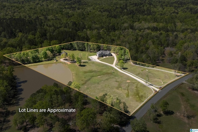 birds eye view of property with a water view and a wooded view