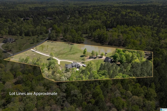 birds eye view of property with a wooded view and a water view