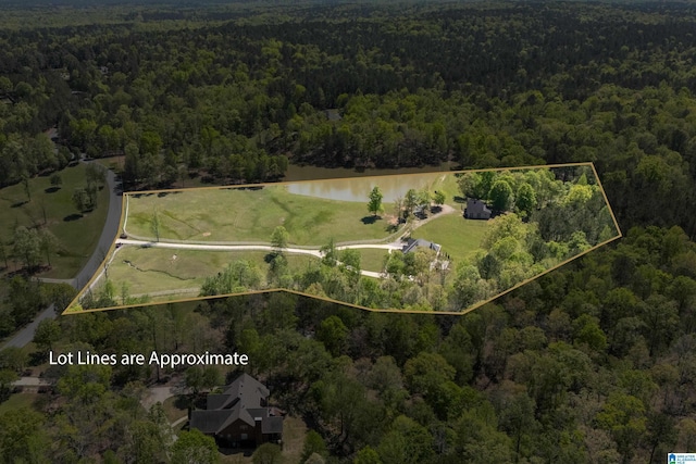 drone / aerial view featuring a wooded view and a water view