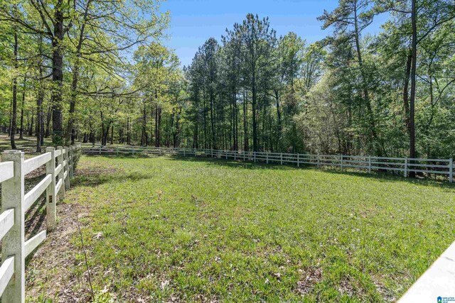 view of yard with a fenced backyard and a wooded view