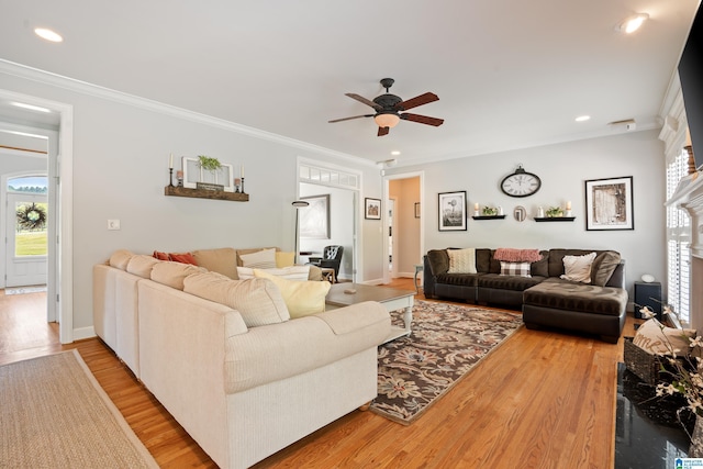 living area with a ceiling fan, wood finished floors, ornamental molding, and a healthy amount of sunlight