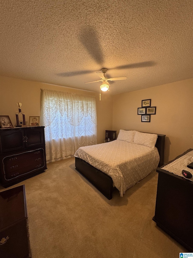 bedroom featuring carpet floors, a textured ceiling, and ceiling fan