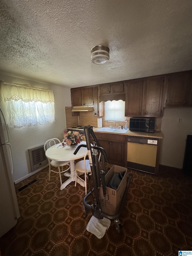 kitchen featuring freestanding refrigerator, dishwashing machine, black microwave, a sink, and heating unit