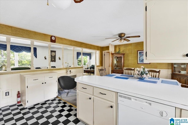 kitchen with dishwasher, a peninsula, white cabinetry, and tile patterned floors