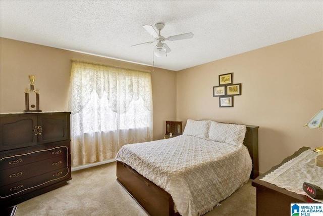 bedroom featuring ceiling fan, a textured ceiling, and light colored carpet