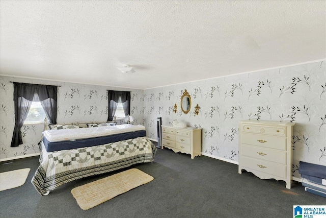 bedroom featuring dark colored carpet, a textured ceiling, and wallpapered walls